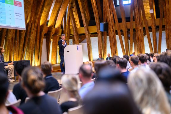 Rektor auf Podium, davor Publikum sitzend