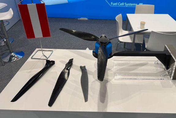 Kleiner Propeller, daneben drei Rotorblätter auf dem Tisch