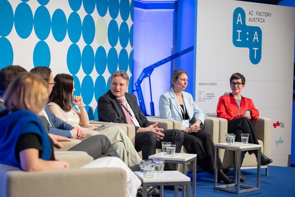 Sieben Personen auf im Halbkreis stehenden Sesseln