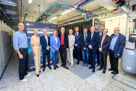 11 Personen stehen für Gruppenfoto im Serverraum von MUSICA