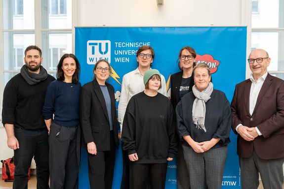 Gruppenfoto Menschen stehend, dahinter blaue Wand