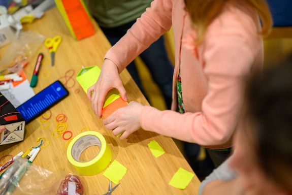 Tisch von oben mit Bastelsachen und Kinderhänden