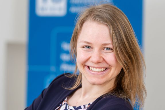 Forscherin lächelnd mit verschränkten Armen