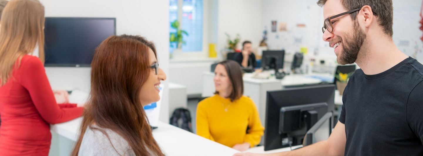 Mitarbeiter berät Studentin im Service Center