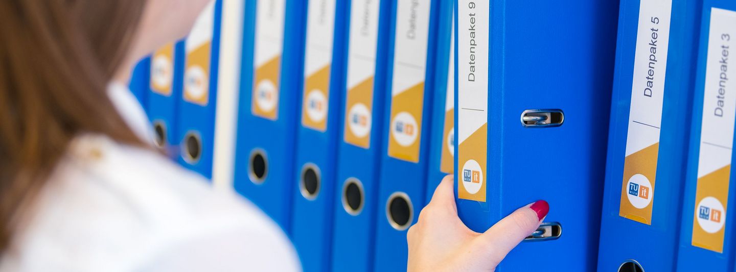 Lady takes folder from shelf