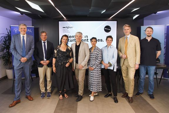 Gruppenfoto von der Pressekonferenz – im Hintergrund kann man diverse Rollups erkennen. Im Vordergrund stehen von rechts nach links Rubert Sausgruber (Rektor, Wirtschaftsuniversität Wien), Jens Schneider (Rektor, Technische Universität Wien), Veronica Kaup-Hasler (Amtsführende Stadträtin für Kultur und Wissenschaft, Stadt Wien), Erich Prem (Conference Chair, Obmann des Vereins zur Förderung des digitalen Humanismus), Rumman Chowdhury (Gründerin Humane Intelligence PBC, ehemalige U.S. Science Envoy for AI; Keynote-Speakerin der Konferenz), Eva Wittenberg (Offizielle Vertretung von Carsten Q. Schneider, Central European University), Sebastian Schütze (Rektor, Universität Wien), Peter Knees (TU Wien, designierter Leiter CDH Vienna)