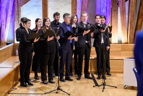 Chor: Menschen in schwarzem Gewand stehend