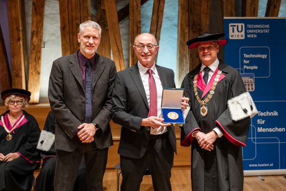 Three people in the Kuppelsaal at TU Wien