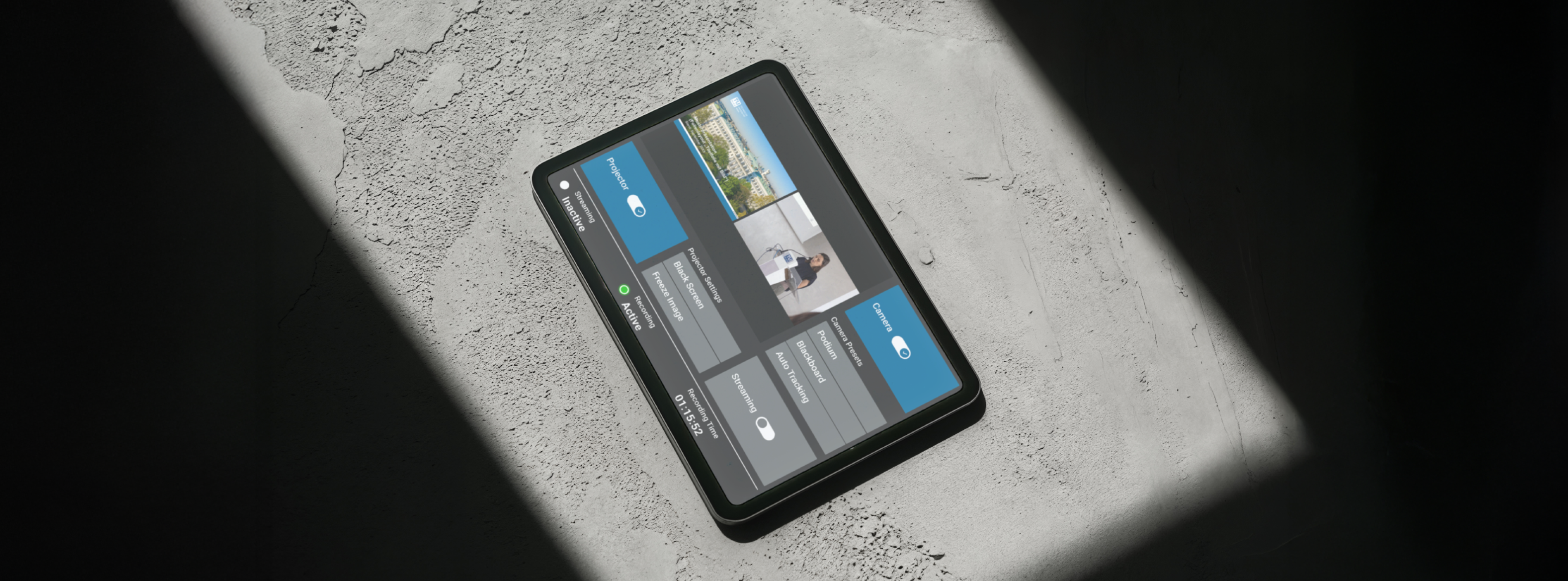 Tablet mit Touchpanel-Benutzeroberfläche zur Hörsaalsteuerung auf Betonboden mit Schatten